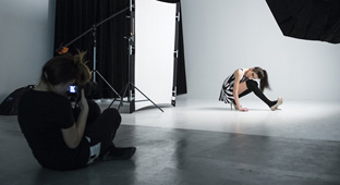 Une étudiante photographie un mannequin vétu de noir et blanc dans l'un des studios, programme Photographie, La Cité.