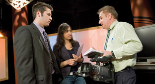 Discussion entre un caméraman, une réalisatrice et un journaliste.