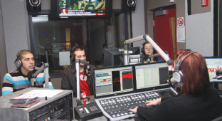 Quatre étudiants en radiodiffusion participent à une émission en studio.